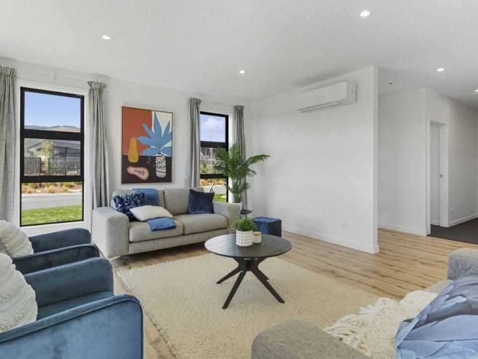Staged living room with blue velvet chairs and botanical artwork