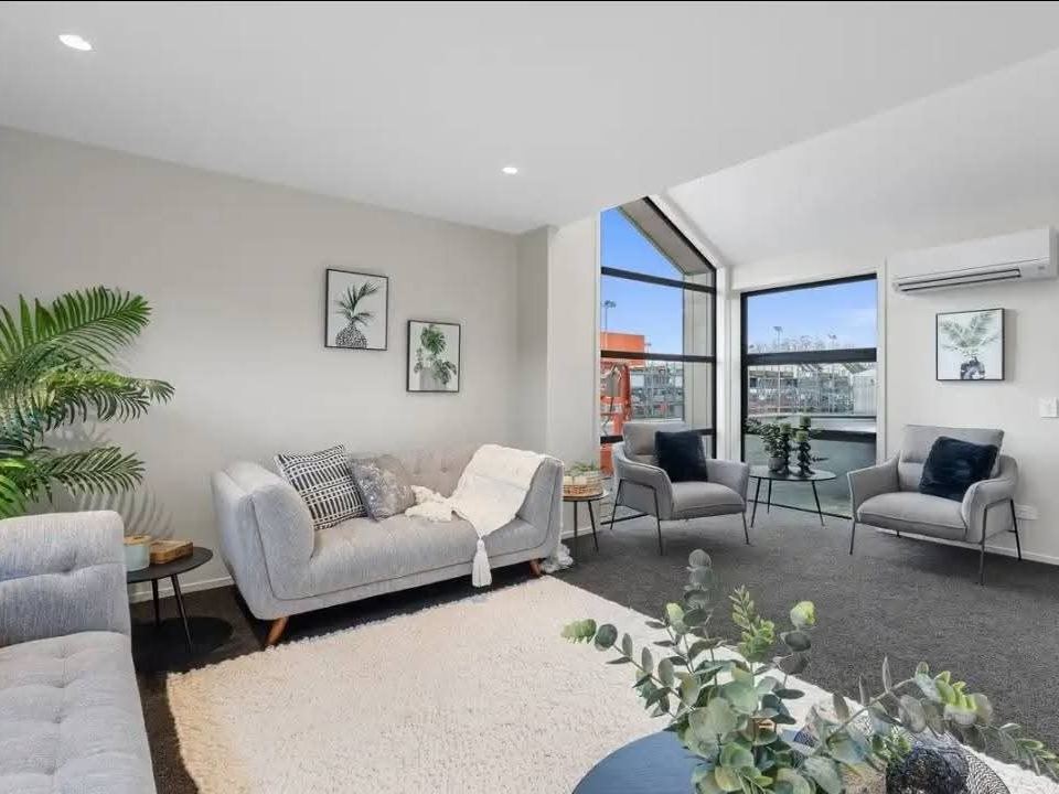 Staged lounge with grey sofas and cream rug