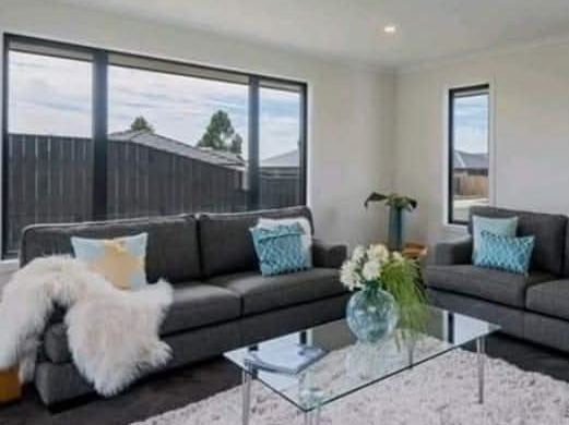 Staged lounge with charcoal sofas and teal cushions
